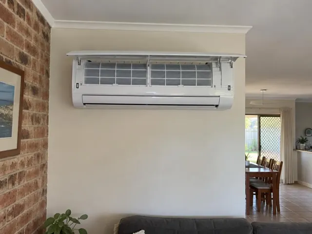 Clean split system with open front panel and visible filters on a painted internal wall in a home in Nerang